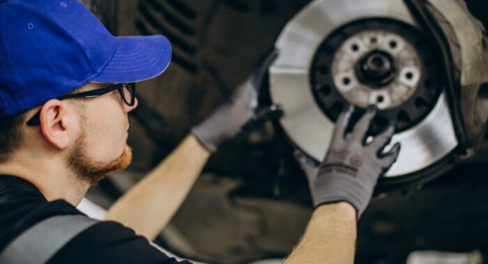 mecánico revisando auto que sufre vibraciones al frenar mecánico revisando auto que sufre vibraciones al frenar