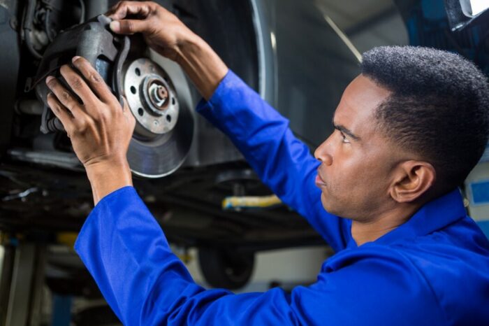 mec&aacute;nico revisando el freno del coche de la fijaci&oacute;n del mec&aacute;nico