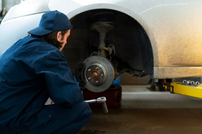 mecánico revisando el sistema de frenos ABS de un vehiculo en mantenimiento