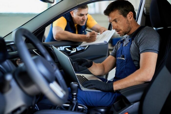 mec&aacute;nicos revisando el control de estabilidad de un auto