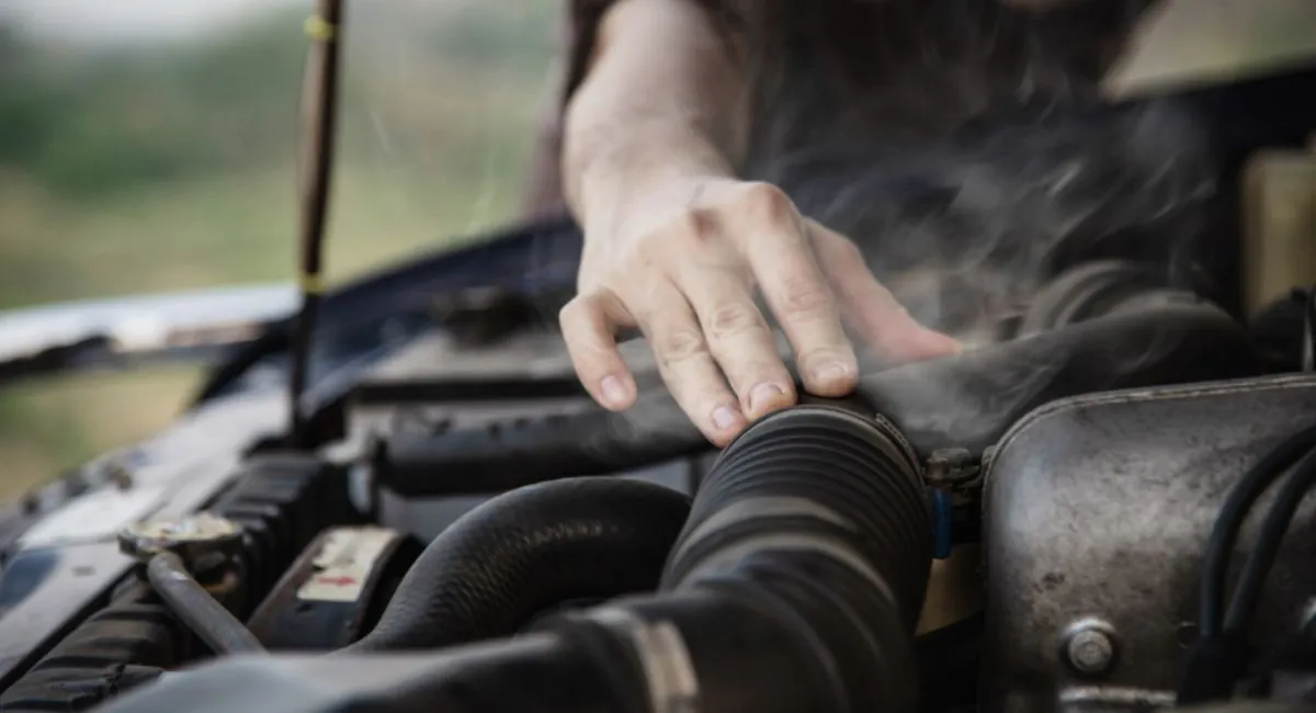 hombre revisa los motivos del sobrecalentamiento de motor del carro